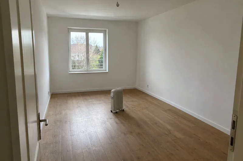 Empty room with a single portable electric heater on the floor