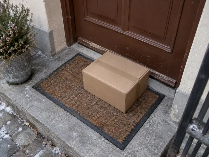 Cardboard parcel left on a doorstep in winter